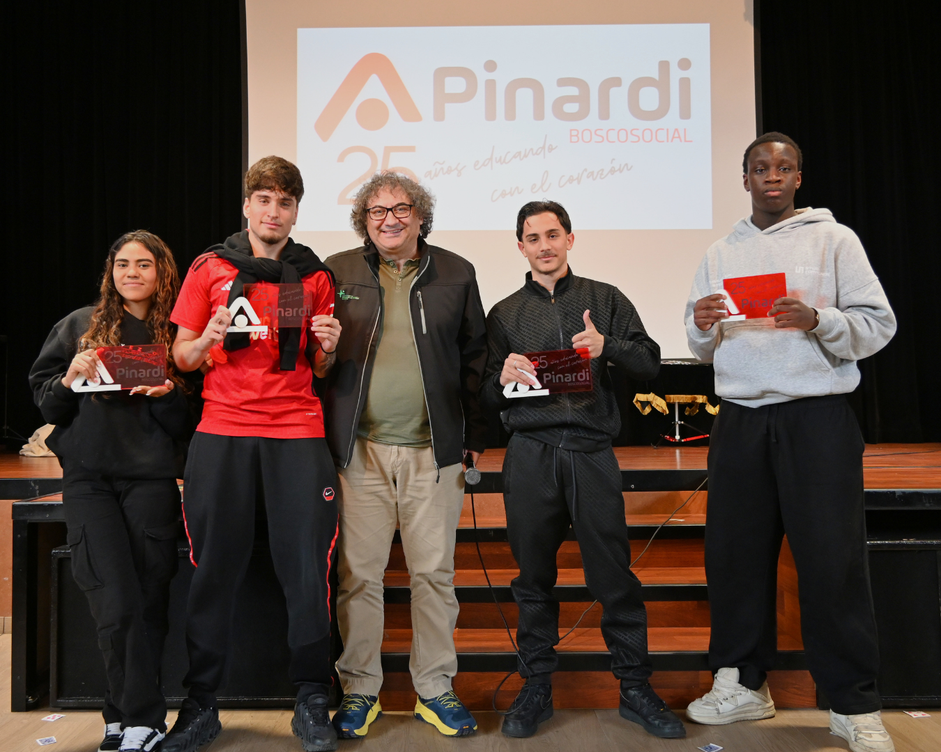 Farruco posando con alumnos junto sus placas del 25 aniverasario