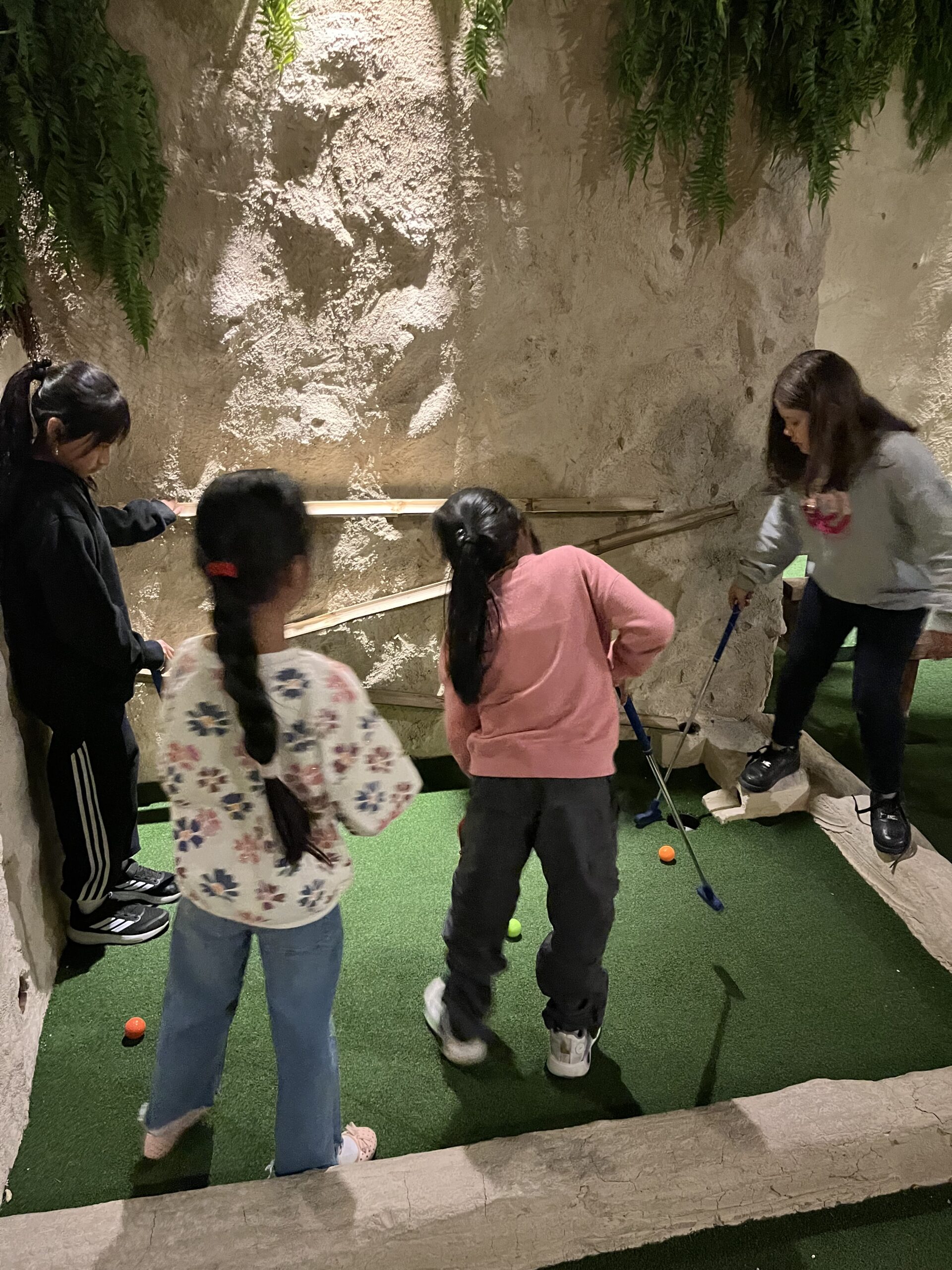 Las chicas juegan al minigolf durante el campamento de Semana Santa realizado por Pinardi.