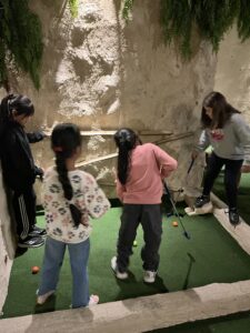 Las chicas juegan al minigolf durante el campamento de Semana Santa realizado por Pinardi.