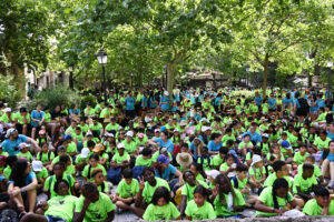 Más de 850 niños, niñas y adolescentes de Pinardi escuchan un mensaje de bienvenida durante su visita a Parque de Atracciones de Madrid.